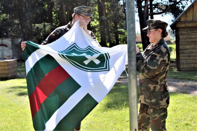 Rokiškio jaunieji šauliai prieš varžybas kabina šaulių sąjungos vėliavą.