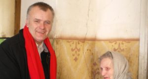 Kiekvieną dieną šiltą maistą vienišiems senoliams į namus vežantis Darius Jasinevičius šv. Velykų proga sveikina Angelę Prascienienę. R. Jakulienės nuotr.