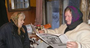 Bronislava Vasalauskaitė (kairėje) net apakusi liko ištikima “Gimtojo Rokiškio“ skaitytoja: naujienas jai perskaito paštininkė Stasė Krasauskienė. A.Puteikytės nuotr.
