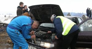 Klaida posūkyje sportininkui Romanui Terechovui kainavo brangiai: teko skubiai krapštyti sniegą iš po automobilio kapoto. L.Dūdaitės nuotr.