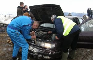 Klaida posūkyje sportininkui Romanui Terechovui kainavo brangiai: teko skubiai krapštyti sniegą iš po automobilio kapoto. L.Dūdaitės nuotr.