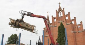 Darbininkai krovė medžio rąstus prie bažnyčios šventoriaus. D.Zibolienės nuotr.
