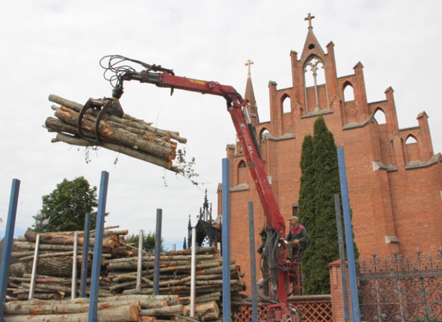 Darbininkai krovė medžio rąstus prie bažnyčios šventoriaus. D.Zibolienės nuotr.