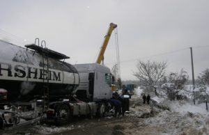 Užtvertas kelias didina pasipiktinimą Dyzelino pasikrauti į Bryzgių kaimą vykęs vilkikas posūkyje įlėkė į griovį. Sunkiasvorę su cisterna ant kelio ištraukė kelininkų technika. A.Minkevičienės nuotr.