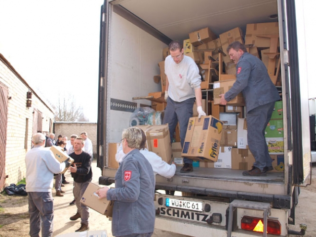 Estenfeldo maltiečiai iškrauna atgabentus mokyklinius stalus ir įvairias dovanas vaikams. D.Zibolienės nuotr. Estenfeldo maltiečiai iškrauna atgabentus mokyklinius stalus ir įvairias dovanas vaikams. D.Zibolienės nuotr.