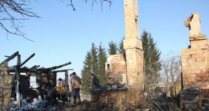 Gaisravietėje susirinkę Bagdoniškio gyventojai bandė atjungti sudegusio namo vandentiekio sistemą. D.Zibolienės nuotr.