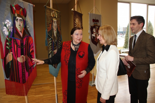 Scenografė S. Kanaverskytė (kairėje) pasakoja apie vėliavų siūvimo rankomis techniką parodos atidaryme dalyvavusiems lankytojams. A. Mackuvienės nuotr.