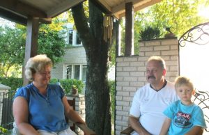 Danguolė ir Aloyzas Jočiai: apie velveto kelnes, užkurio gyvenimą, geltoną žiguliuką ir sekmadienio kiaušinienę Danguolės ir Aloyzo Jočių šeimos gyvenimas vasarą persikelia į po medžiais skendinčią verandą. Su anūku Adomu. A. Minkevičienės nuotr.