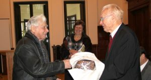 Ūkininkų sąjungos pirmininkas Vytautas Šlikas (kairėje) dovanojo akademikui Leonardui Kairiūkščiui rajono žemdirbių užaugintą ir iškeptą duoną. Viduryje - renginio vedėja Krašto muziejaus direktorė Nijolė Šniokienė. D.Zibolienės nuotr.