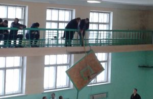 Varžybų organizatoriai ir sirgaliai skilusią krepšinio lentą iškėlė į balkoną. R. Kilkaus nuotr.