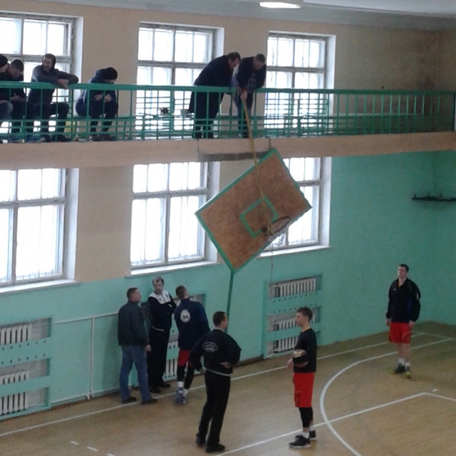 Varžybų organizatoriai ir sirgaliai skilusią krepšinio lentą iškėlė į balkoną. R. Kilkaus nuotr.