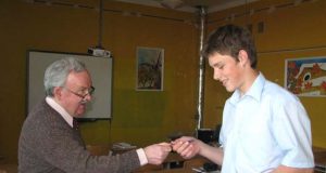 P.S.Krivickas (kairėje) už teisingą atsakymą K.Gurkliui įteikė knygą. N.Byčkovskio nuotr.