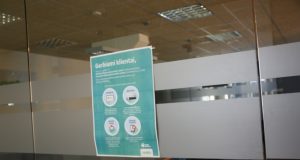 Vietoje įmonės specialistų - užrakintos durys ir plakatas.