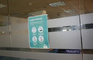 Vietoje įmonės specialistų - užrakintos durys ir plakatas.