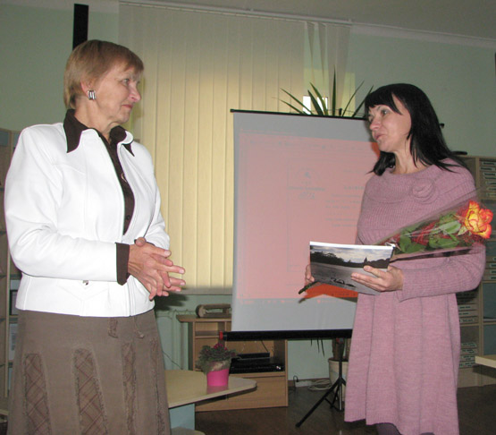 Bibliotekininkė Daiva Vilkickienė (dešinėje) viešniai įteikė Rokiškio krašto kultūros žurnalą „Prie Nemunėlio“.