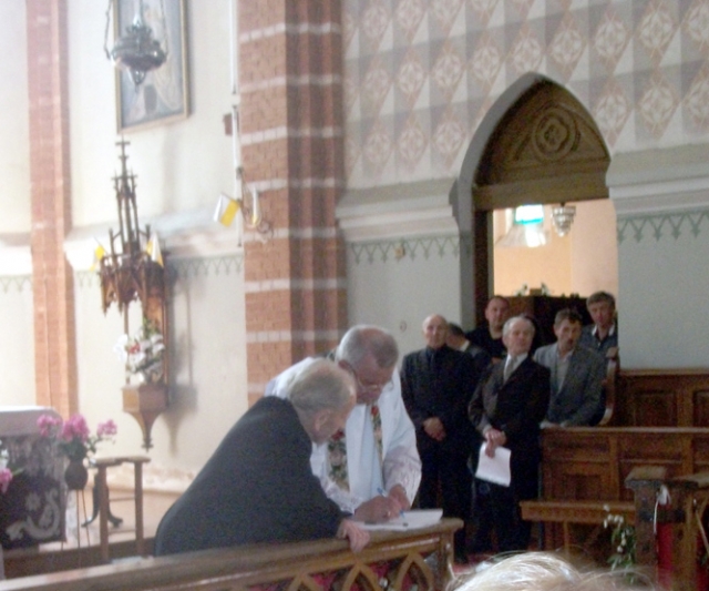 Bažnyčios perdavimo aktą pasirašo kunigai Vladas Kremenskas (kairėje) ir Vilnis Viktoras Cukuras. Asmeninio albumo nuotr.