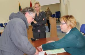 Rinkimų apylinkės narė Jolita Žemaitienė (dešinėje) patikrino G.Navikienės asmens dokumentus ir išdavė jai rinkimų biuletenį. D.Zibolienės nuotr.