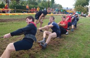 Virvės traukimo varžybų akimirka: Kriaunų komandai buvo nelengva įveikti specialiais batais išmindytą Kūno kultūros ir sporto centro stadiono veją. L. Dūdaitės nuotr.