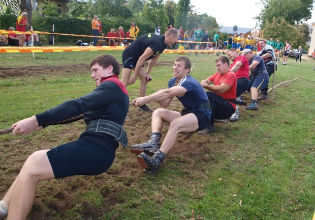 Virvės traukimo varžybų akimirka: Kriaunų komandai buvo nelengva įveikti specialiais batais išmindytą Kūno kultūros ir sporto centro stadiono veją. L. Dūdaitės nuotr.