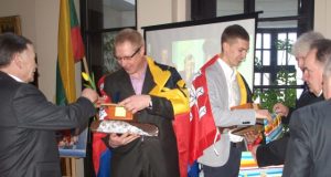 Olimpiečius Gitą Juškevičių ir Raivydą Stanį rajono meras Vytautas Vilys ir Seimo narys Vytautas Saulis apsiautė Rokiškio vėliavomis. L.Dūdaitės nuotr.