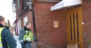 Policijos pareigūnai Romas Navikas (kairėje) ir Henrikas Siniauskas bandė pagaliu nuo durų nuvyti šunį.