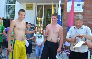 Obeliuose lenktyniavo dviratininkai Nugalėtojai E.Streikus (kairėje) ir L.Tarvydavičius džiaugėsi seniūno E.Narkūno įteikta taure bei medaliais. V.Jocio nuotr.