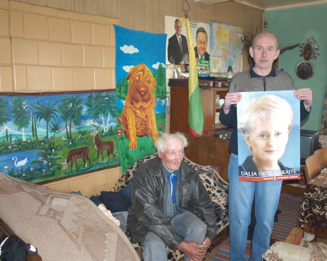 Norėdamas atšvęsti rinkimus Skemų pensionato gyventojas Vladimiras Butaikis (su rinkimus laimėjusios Dalios Grybauskaitės plakatu) pusdykiai pardavė kilimą Jonui Varnui. D.Zibolienės nuotr.